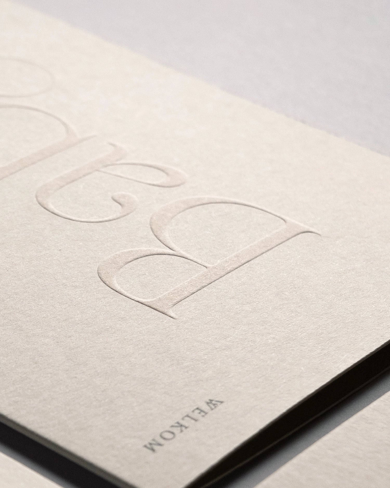 Close-up of minimal luxury embossed new baby card “welkom lieve kleine baby” on Colorplan Mist paper