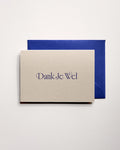 Top view of minimal luxury letterpress thank you card “dank je wel” on Colorplan Mist paper with royal blue envelope