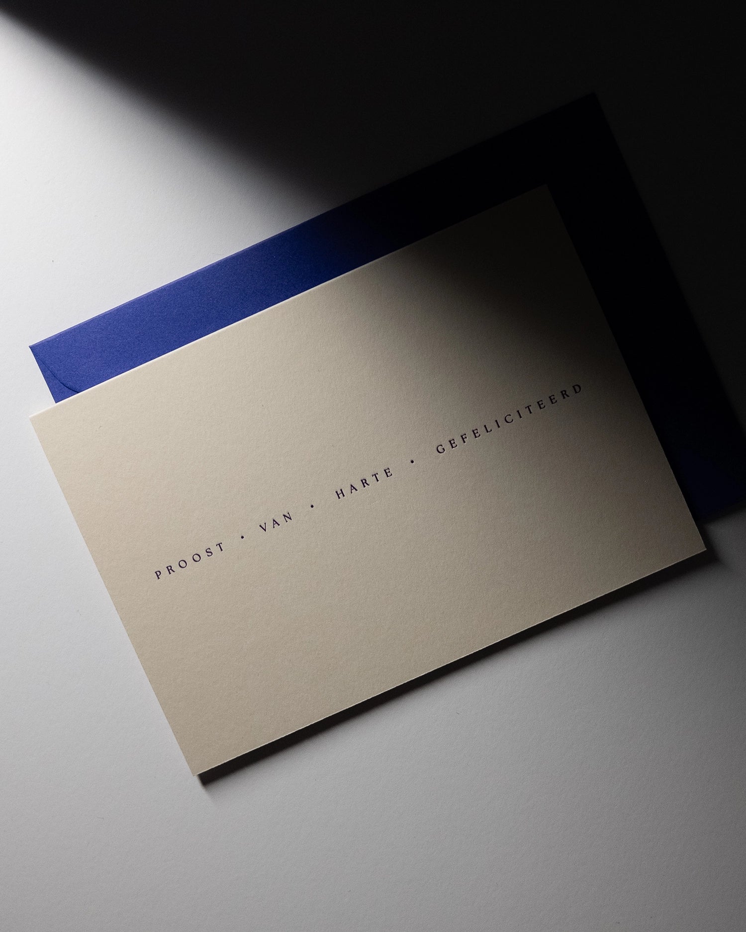 minimal luxury celebration card “proost van harte gefeliciteerd” with shadows on Colorplan Mist paper
