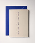 Top view of minimal luxury letterpress celebration card “proost van harte gefeliciteerd” on Colorplan Mist paper with royal blue envelope