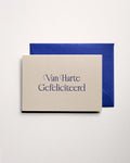 Top view of minimal luxury letterpress brithday card “van harte gefeliciteerd” on Colorplan Mist paper with royal blue envelope